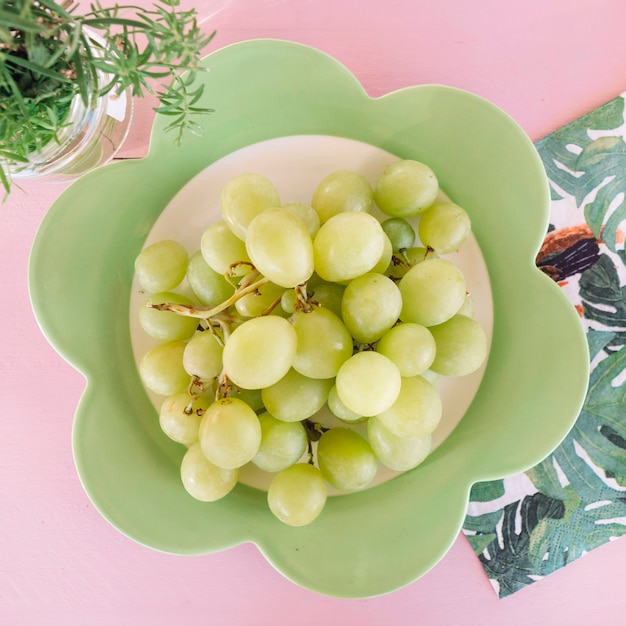 Overhead view of fresh green grapes on floral shaped plate