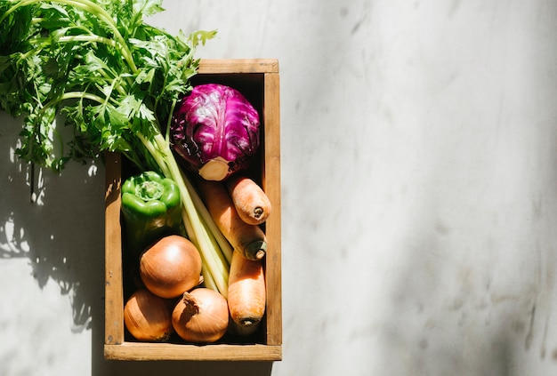 Overhead view of fresh vegetables in wooden tray