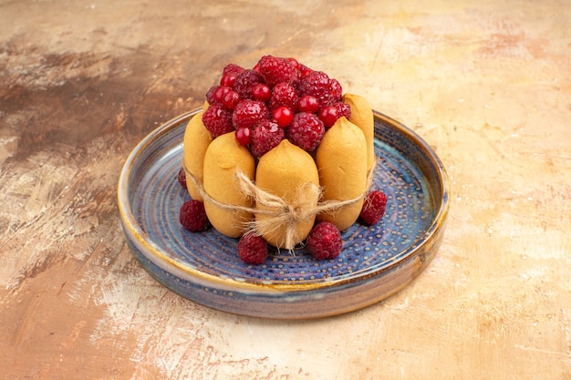 Free photo overhead view of freshly baked gift cake with fruits on a blue tray on mixed color table