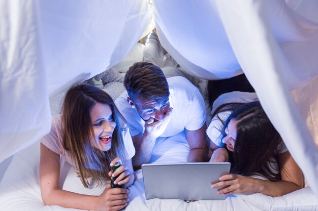 Overhead view of friends watching on digital tablet making fun