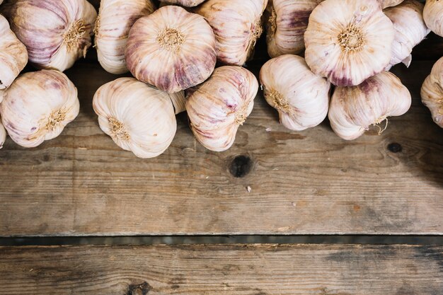 Накладной вид чесночных луковиц на деревянный стол
