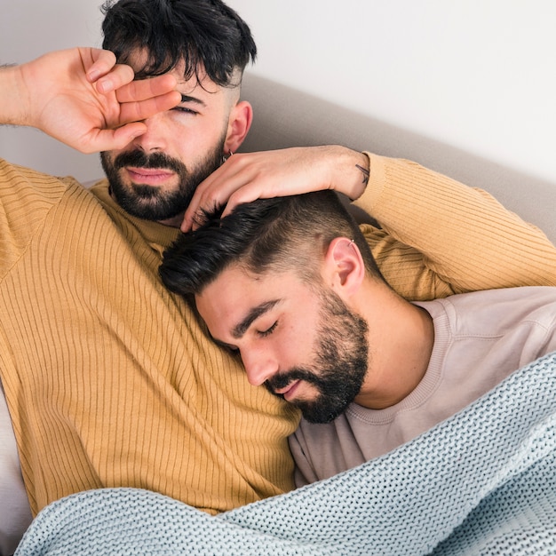 An overhead view of gay couple relaxing on sofa