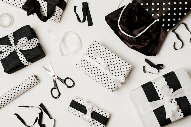 Overhead view of gift boxes with design paper; scissor and paper bag