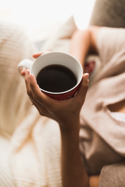 An overhead view of a girl holding coffee cup in hands