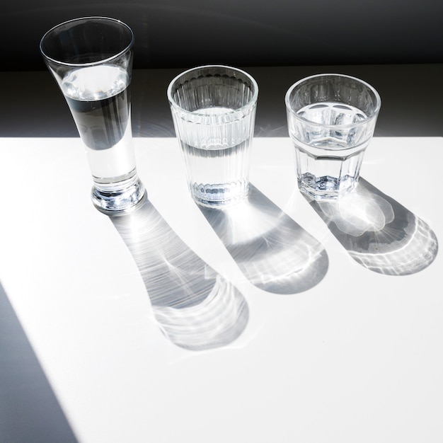 Free photo an overhead view of glasses with shadow on white background