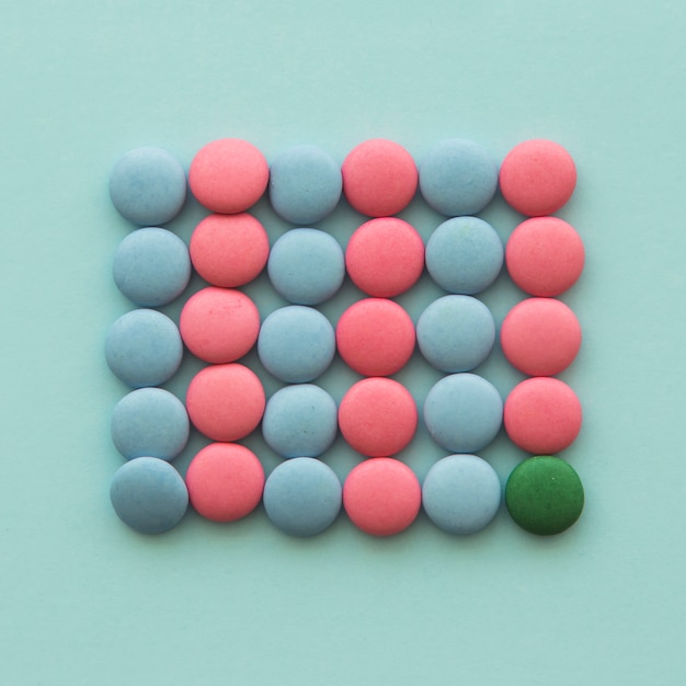 Overhead view of green candy with pink and blue candies