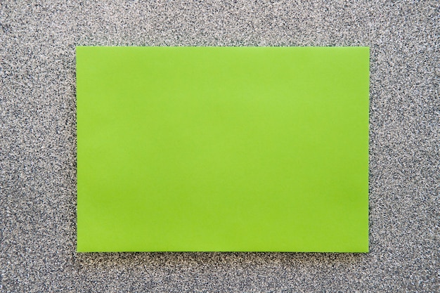 Overhead view of green cardboard paper on grey backdrop