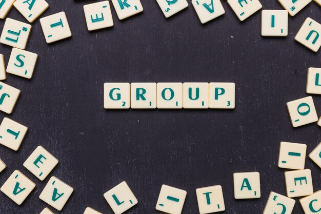 Overhead view of group text on scrabble letters over black backdrop