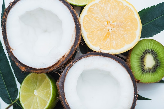 An overhead view of halved coconut; lime; lemon and kiwi