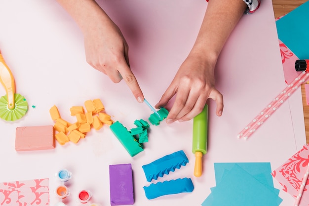 Overhead view of hand cutting colorful clay