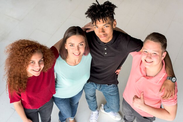 Overhead view of happy smiling friends looking up at camera