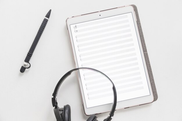 Overhead view of headphone on graphic digital tablet and stylus pen one white background