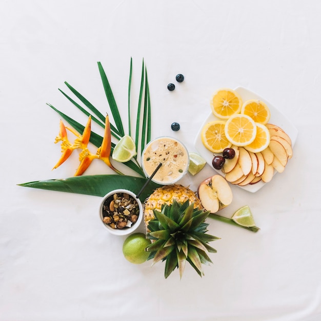 An overhead view of healthy breakfast with bird of paradise flower on white backdrop