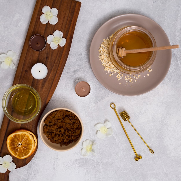 An overhead view of herbal cosmetics products on white texture backdrop