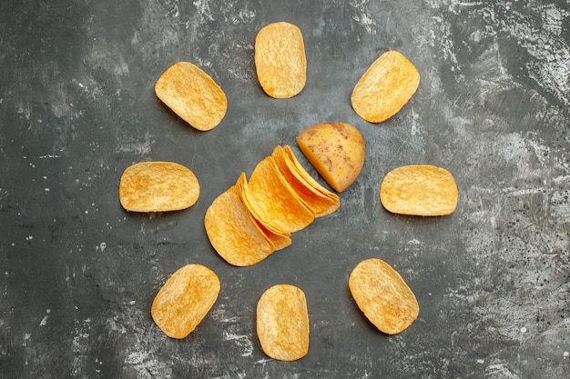 Overhead view of homemade delicious potato chips on gray table