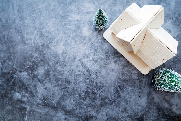 An overhead view of house model with christmas tree on weathered concrete background