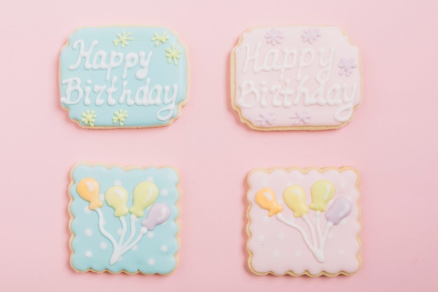 Overhead view of icing cookies over pink background