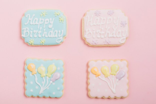 Overhead view of icing cookies over pink background