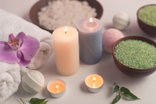 Overhead view of illuminated candles treatment products on white backdrop
