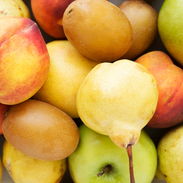 An overhead view of kiwi; peach; apple and pear fruits