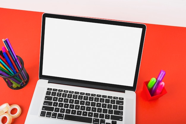 빨간 책상에 화려한 문구와 함께 흰색 화면을 표시하는 노트북의 오버 헤드보기