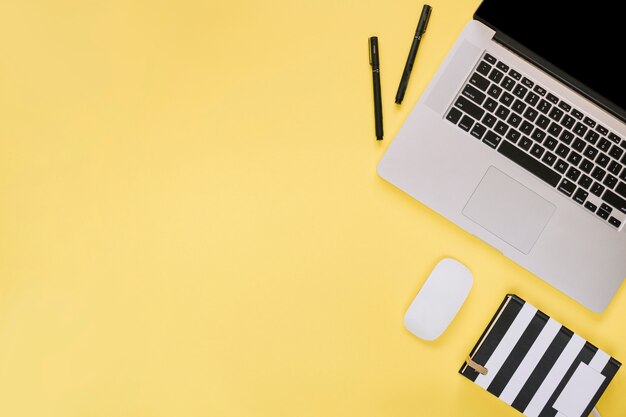 노란색 표면에 노트북 및 문구의 오버 헤드보기