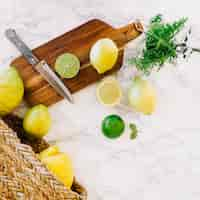 Free photo overhead view of lemon and knife on wooden chopping board