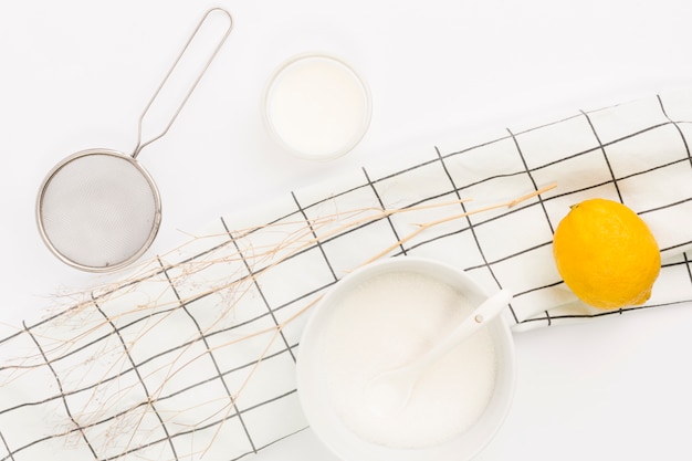 Free photo overhead view of lemon; sugar and kitchen utensil