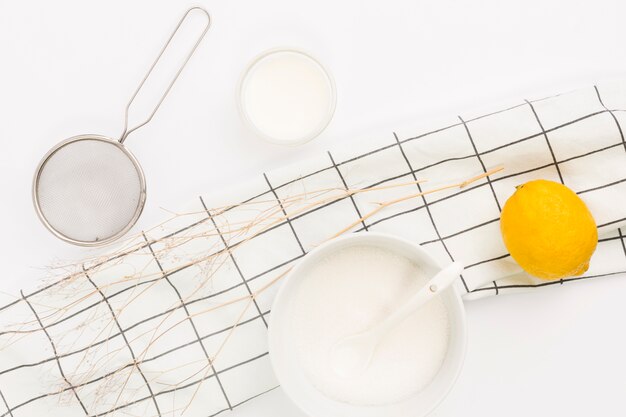 Overhead view of lemon; sugar and kitchen utensil