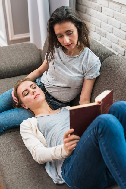 An overhead view of lesbian young couple reading the book at home
