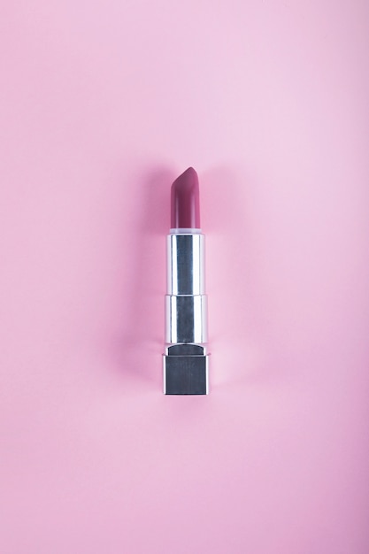 Overhead view of lipstick on pink background