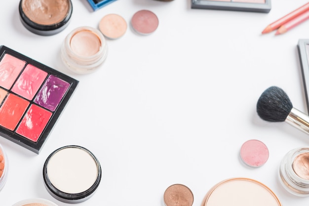 Overhead view of makeup products on white backdrop