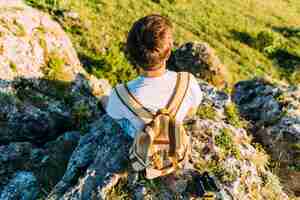 Free photo overhead view of a male hiker with backpack sitting on rock