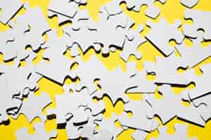 Free photo overhead view of many white jigsaw puzzle pieces