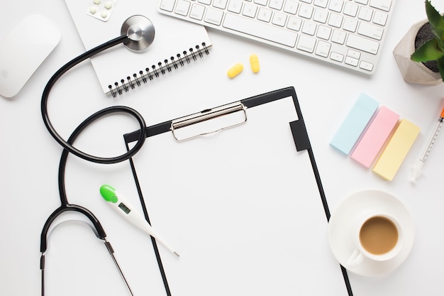 Overhead view of medical desk with coffee cup and adhesive notes on table