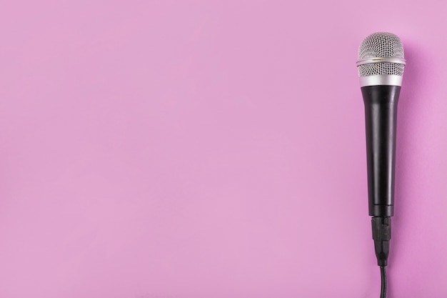 Free photo an overhead view of microphone on pink background