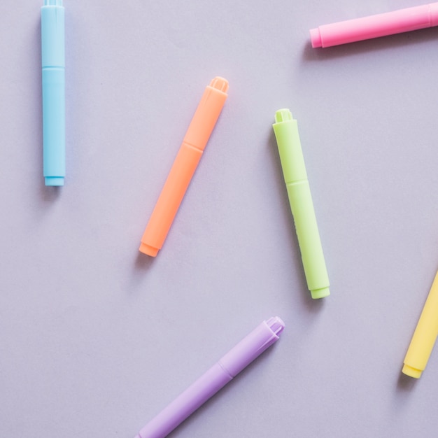 Overhead view of multi colored markers on grey background