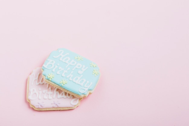 ピンクの背景上の新鮮なクッキーの誕生日のテキストのオーバーヘッドビュー