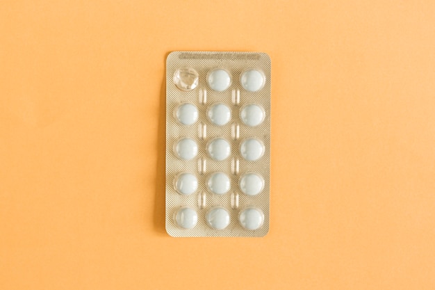 Free photo overhead view of one used tablet blister pack on colored background