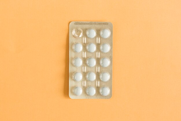 Overhead view of one used tablet blister pack on colored background