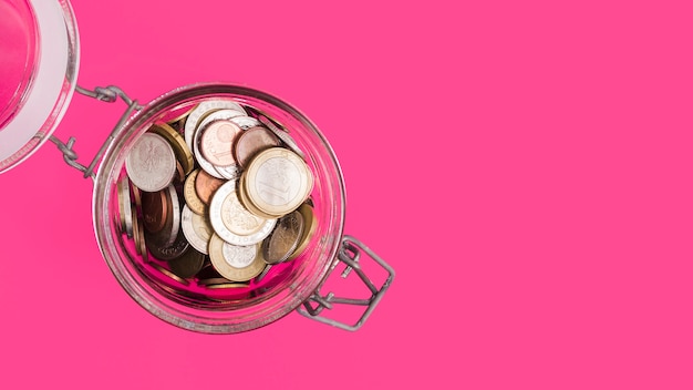 Free Photo An Overhead View Of An Open Glass Jar With Many Coins On Pink Backdrop Free Photo An Overhead View Of An Open Glass Jar With Many Coins On Pink Backdrop