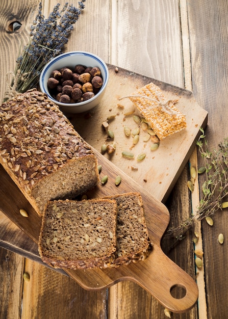 Free photo an overhead view of organic bread and energy bar on chopping board