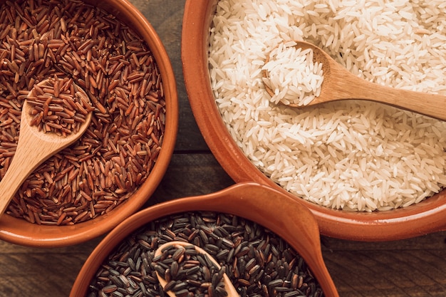 Overhead view of an organic rice grains with wooden spoon