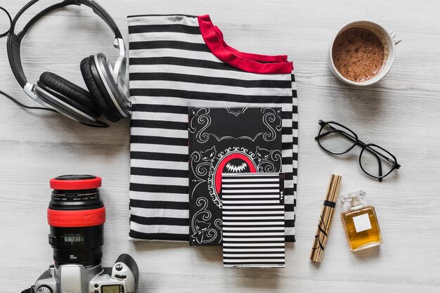 Overhead view of outfits with personal accessories on wooden desk