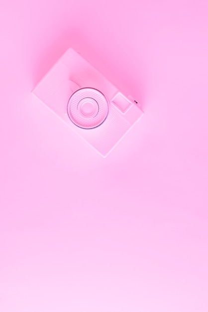 An overhead view of painted camera against pink background