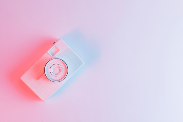 An overhead view of painted camera against pink background