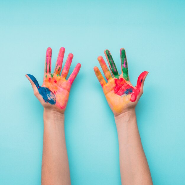 Overhead view of a painted hands on blue backdrop