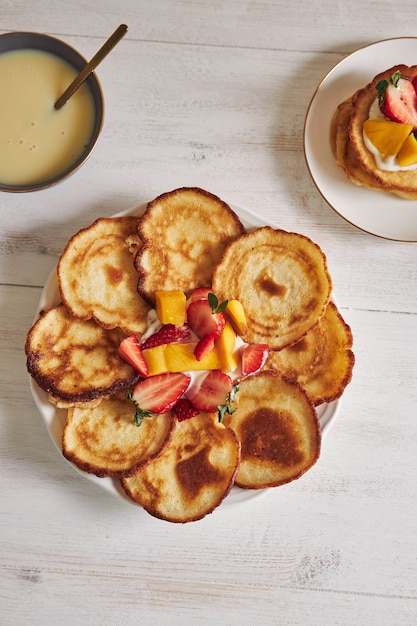 Overhead view of pancakes with fruits in the middle