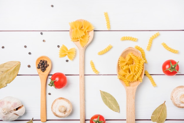 An overhead view of pasta ingredients on white wooden table