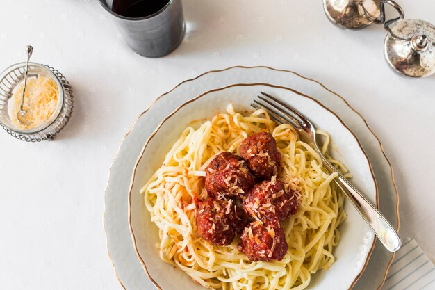 An overhead view of pasta with meatballs in plate